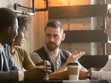 Business owner shares lunch with customers, an example of small business tax write offs